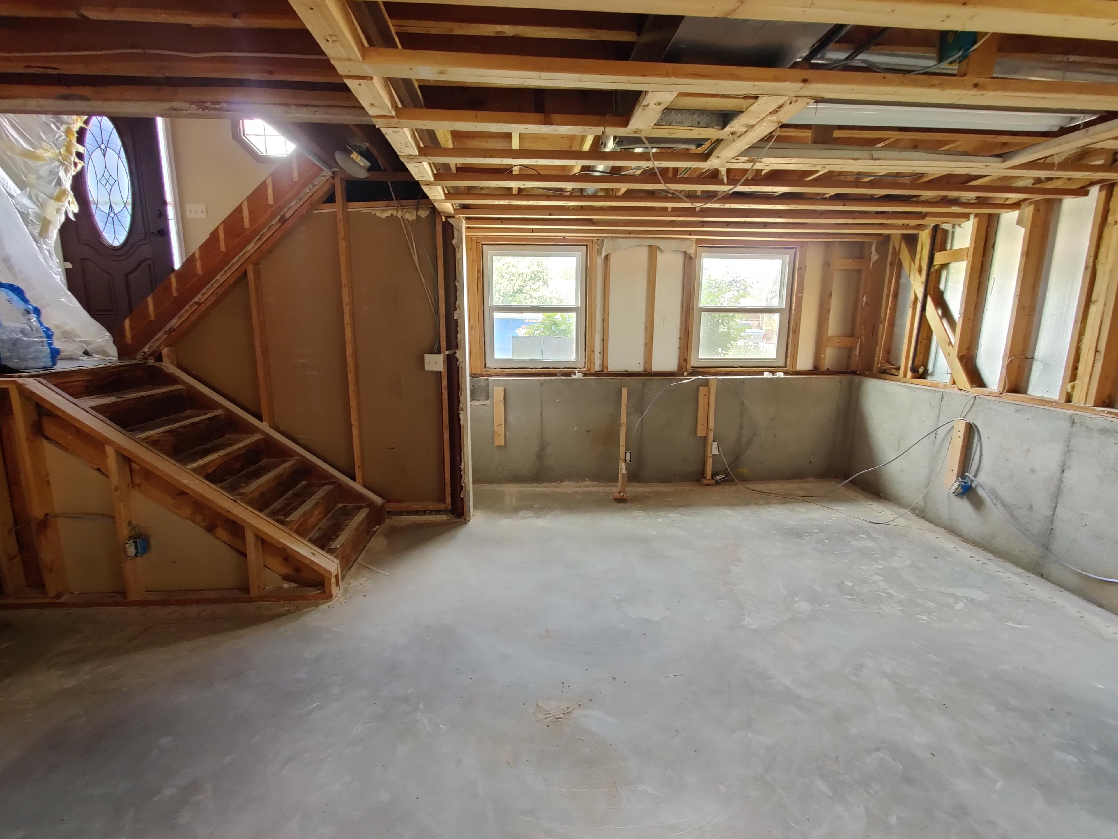 Unfinished basement with exposed framing before post-construction cleaning in Aurora, CO